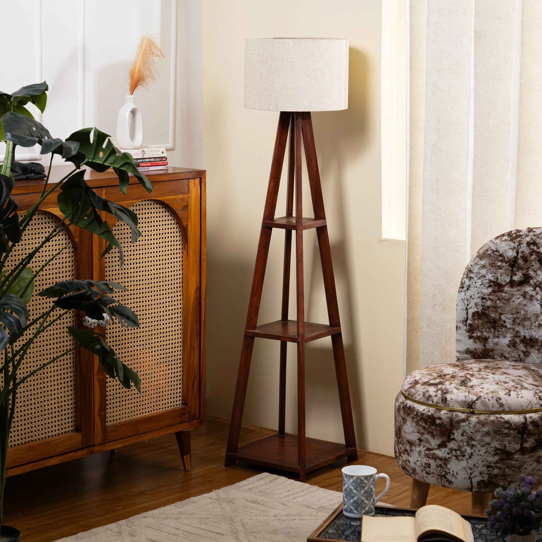 Wooden floor lamp with three shelves in a living room setting.