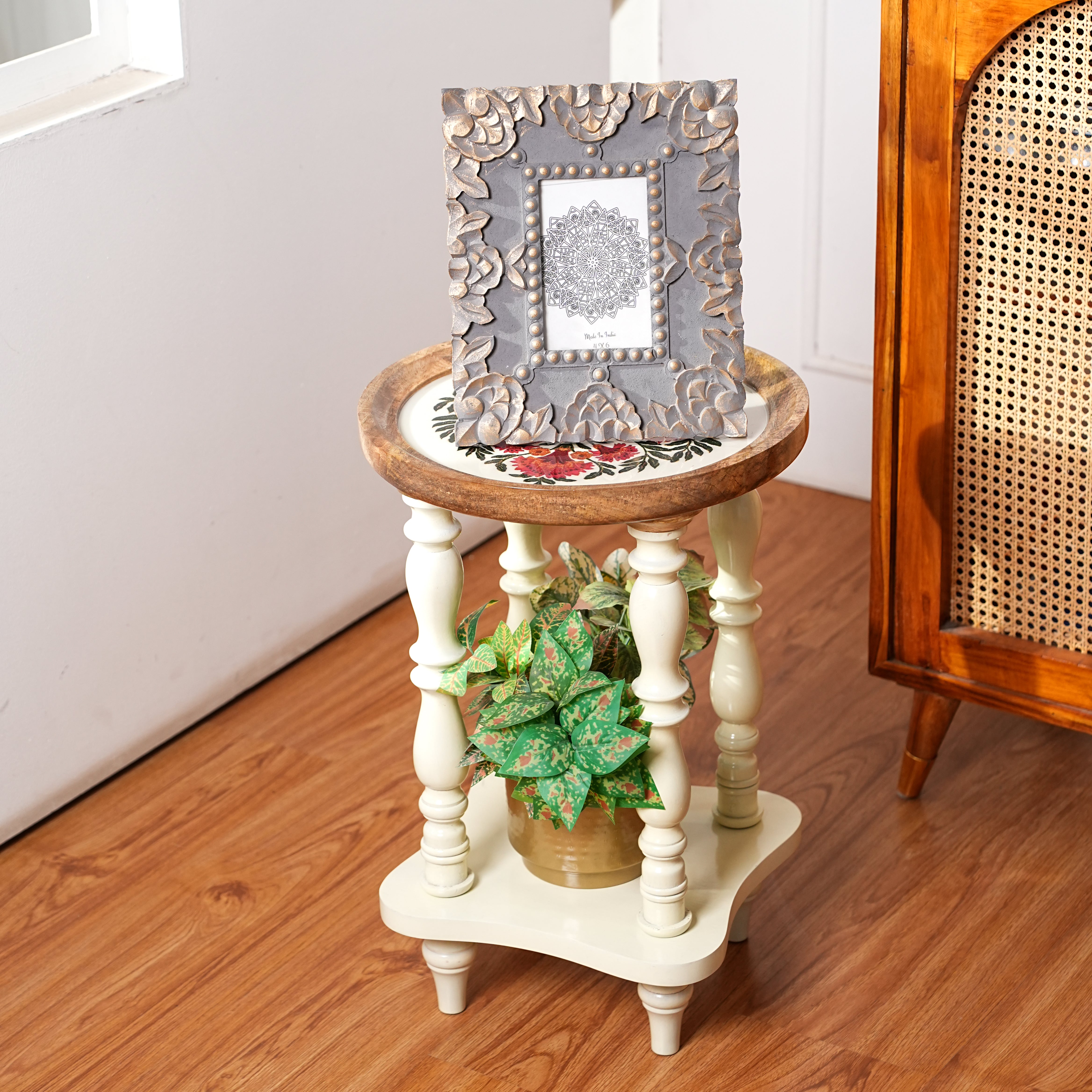 Small wooden side table with decorative items on a wooden floor
