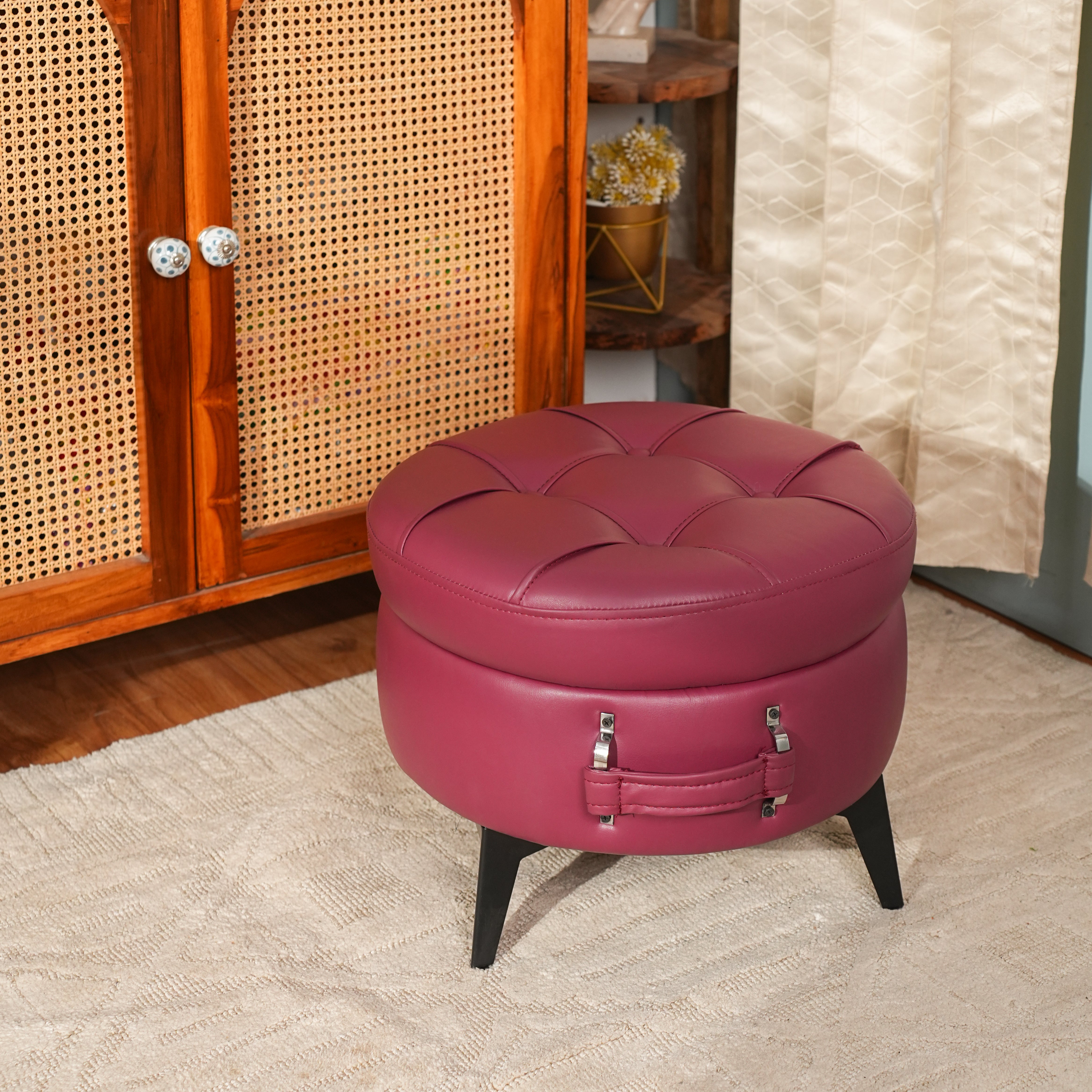 Round pink ottoman with storage compartments on a beige carpeted floor.