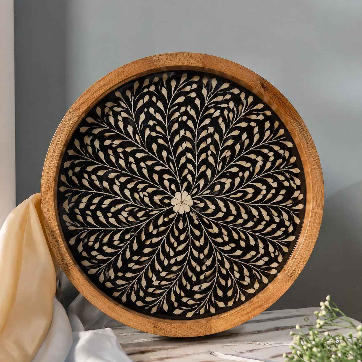 Decorative wall art with a floral pattern inside a wooden frame on a neutral background