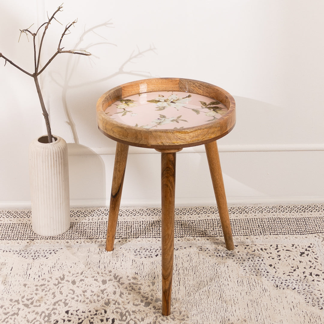 Wooden side table with floral design on a textured rug