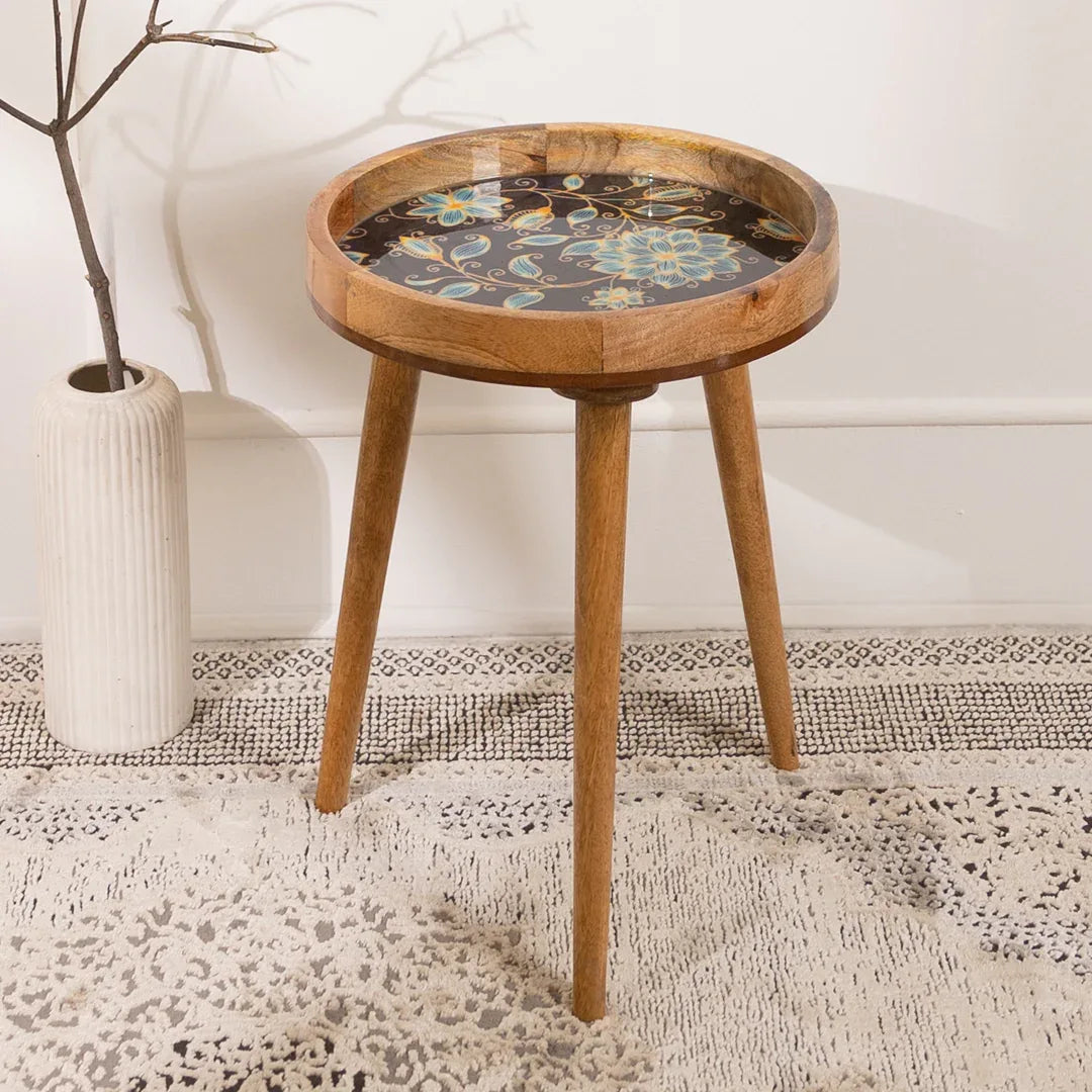 Wooden side table with floral design on a textured rug