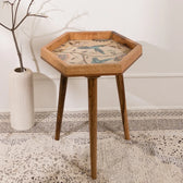 Hexagonal wooden side table with decorative inlay in a room setting.